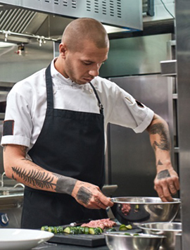 A Lish chef partner preparing eco-friendly meal packs for a corporate catering event using sustainable packaging.