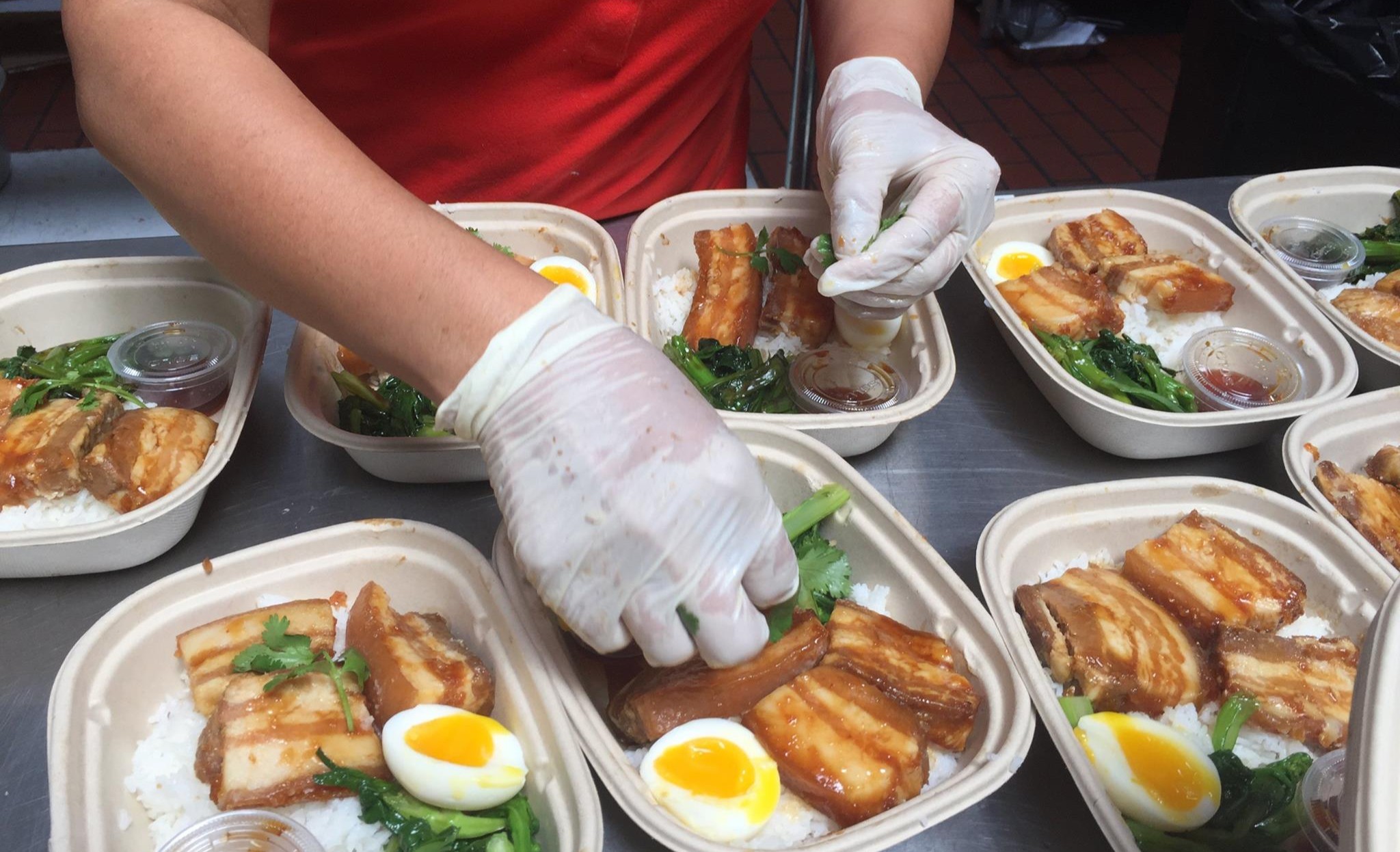 A Lish caterer plating caramelized pork belly for an office holiday lunch.